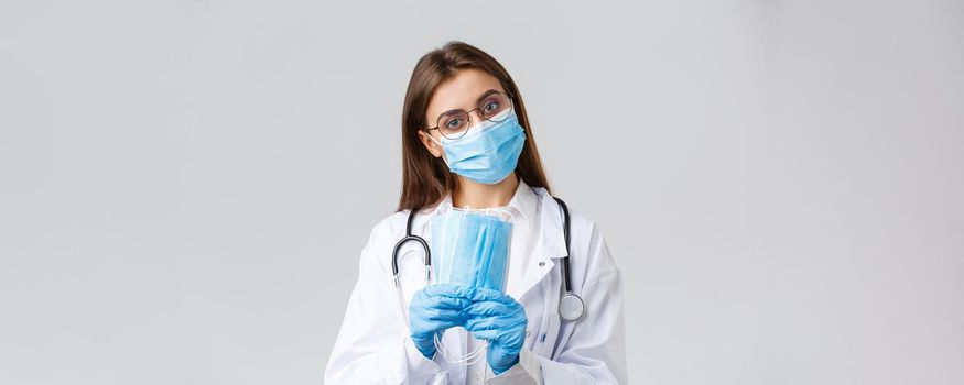 Covid-19, preventing virus, health, healthcare workers and quarantine concept. Professional doctor, physician in personal protective equipment recommend use medical masks, wear scrubs.