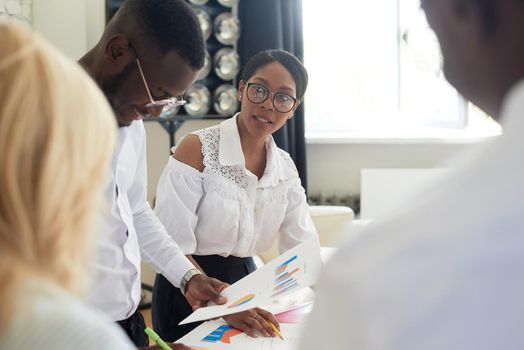 African american female ceo leading corporate multiracial team meeting talking to diverse businesspeople, black woman executive discussing project plan at group multi-ethnic briefing in office.