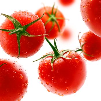 Red tomatoes levitate on a white background.