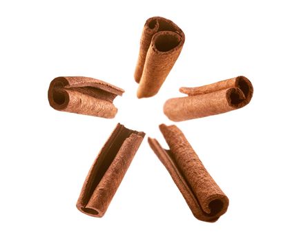 Cinnamon sticks levitate on a white background.