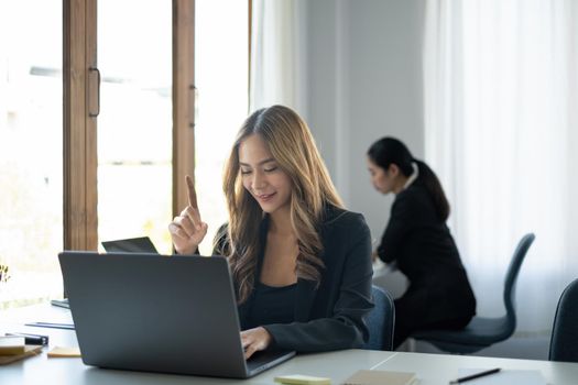 Asian Business woman working to analyze technical price graph and indicator with business team talking by cell phone. account or saving money or insurance concept