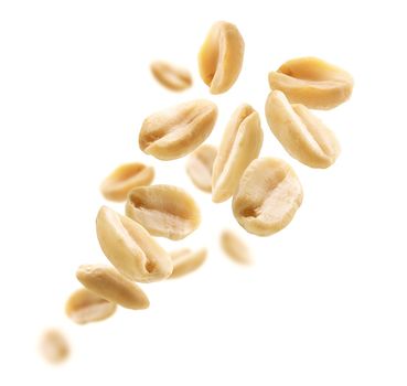 Peeled peanuts levitate on a white background.
