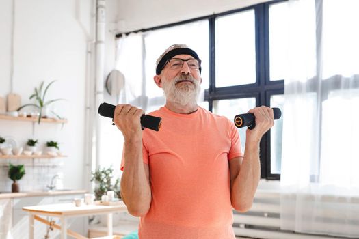 Elderly aged male exercising with dumbbells during online training. Old person man pensioner healthy training healthcare sport at home exercising fitness activity elderly age