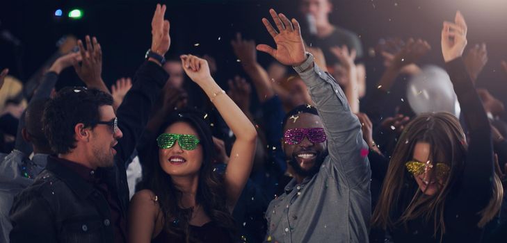 Cropped shot of a group of young friends dancing together in a nightclub.