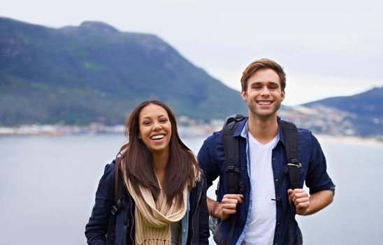 A happy young couple with backpacks enjoying nature.