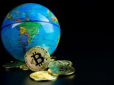 Bitcoin Coins Placed Ahead of a Model World on a black background