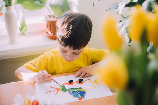 The boy paints a lifestyle . Children's hobby. Leisure at home. Children's drawings. Psychology of children's drawings. Child development.