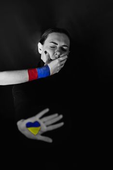 Russia started the war in Ukraine on 24.02.2022. Black white photo of a Ukrainian woman who is covered with her mouth by the Russian Federation.