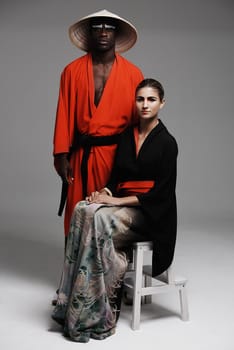 Studio fashion shot of a man and woman wearing oriental-style clothing.