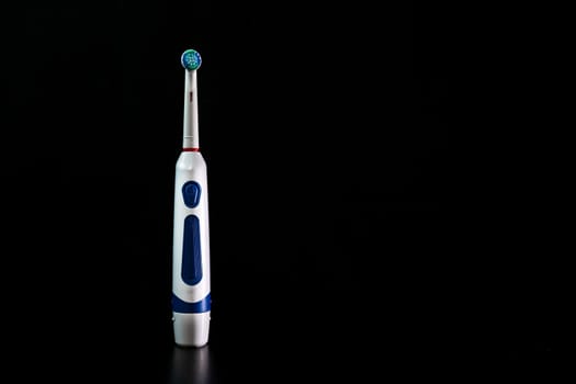 Close up of electric toothbrush isolated on black background.