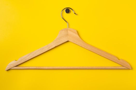 Hanger on colored paper background. Minimalistic fashion concept. Top view