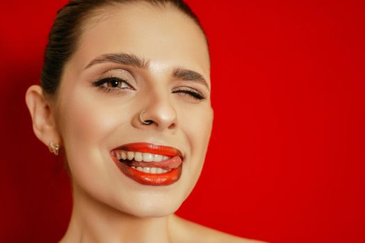 Portrait of a smiling beautiful young woman. Red background. Studio shot