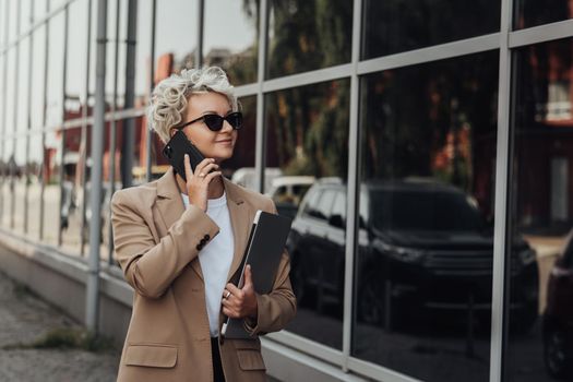 Modern Business Lady Smile and Talking on Phone When Holding Laptop Outdoors