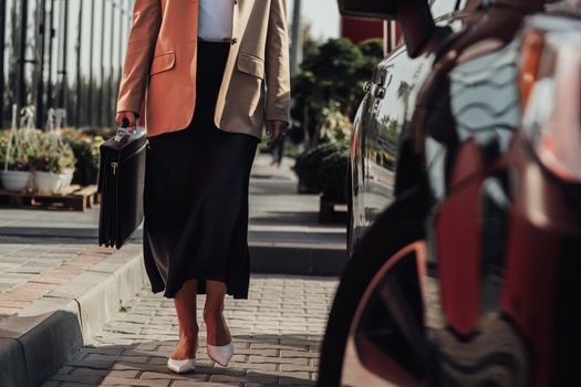 Unrecognisable Elegant Business Woman with Briefcase Moving Near Luxury Car
