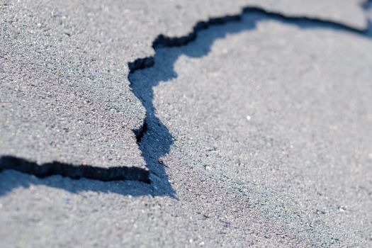 A crack in the pavement on the road. The concept of bad roads.