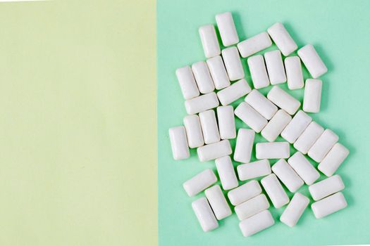 White chewing gums on the yellow and green background, high angle view