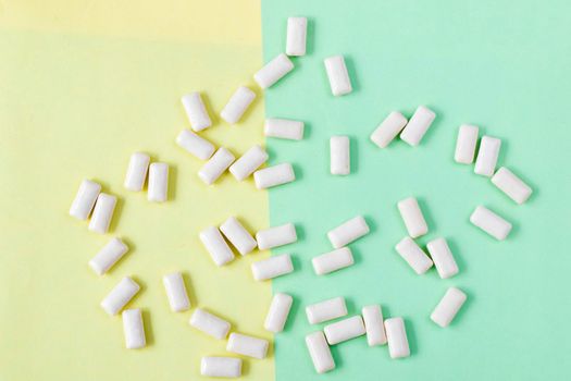 White chewing gums on the yellow and green background, high angle view