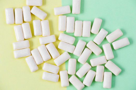 White chewing gums on the yellow and green background, high angle view