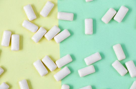 White chewing gums on the yellow and green background, high angle view