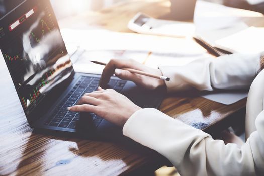 Financial and investment planning concept, female businesswoman using computer to analyze charts to find entry points on a trading board. through digital media via the internet