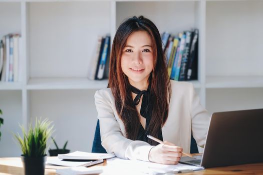 Young economists or accountants or financiers and investors are reviewing budget documents and using computers to study impact and risk assessments on corporate investment management