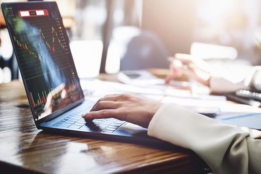 Financial and investment planning concept, female businesswoman using computer to analyze charts to find entry points on a trading board. through digital media via the internet