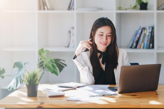 Young economists or accountants or financiers and investors are reviewing budget documents and using computers to study impact and risk assessments on corporate investment management