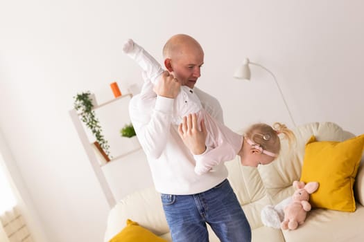 Baby with cochlear implants playing with her mother and father at home.