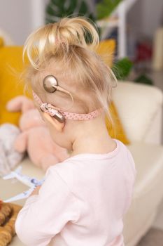 Baby with cochlear implants having fun at home. Deafness and medical technology