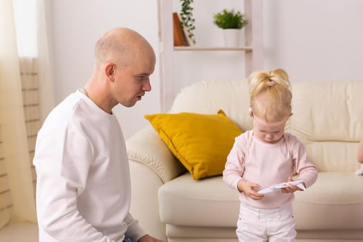 Baby with cochlear implants playing with her mother and father at home.