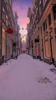 Snowy Red LIght District in winter in Amsterdam the Netherlands at sunset