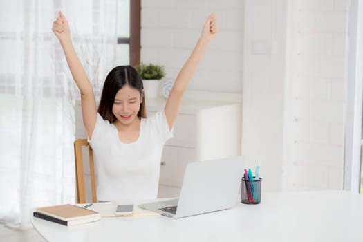 Young asian woman confident working at home with laptop computer and thinking idea for planning, freelance happy girl excited and success using notebook thoughtful and writing, business concept.