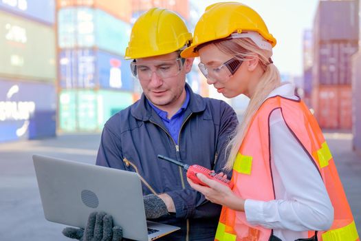 Close up of technician worker man discuss with beautiful co-worker in cargo container shipping area.