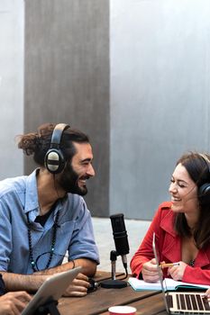 Young caucasian man and woman recording podcast Streaming online using laptop. Vertical image. Copy space. Technology and social media concept.