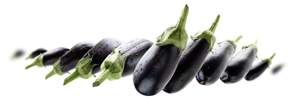 Ripe eggplants levitate on a white background.