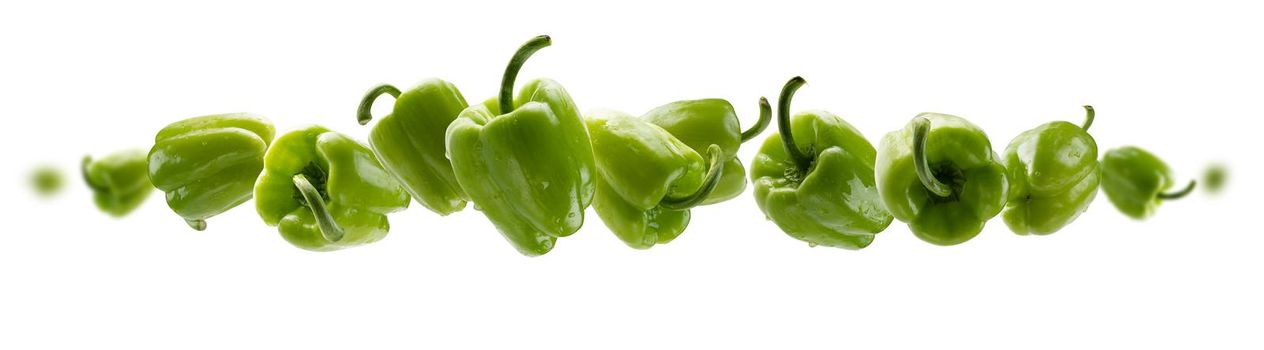 Green paprika levitates on a white background.