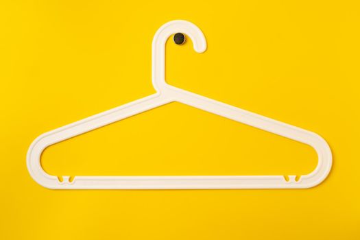 Hanger on colored paper background. Minimalistic fashion concept. Top view