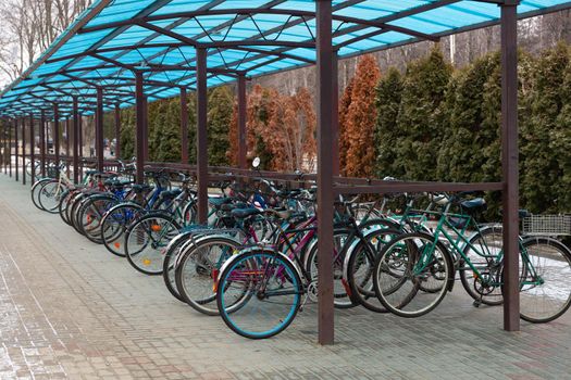 The bicycles of the workers of the one of Belarusian factories are parked in the parking lot under a canopy, while the workers are at work.