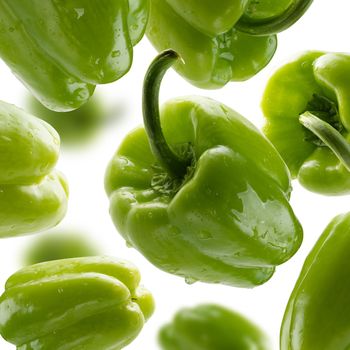 Green paprika levitates on a white background.