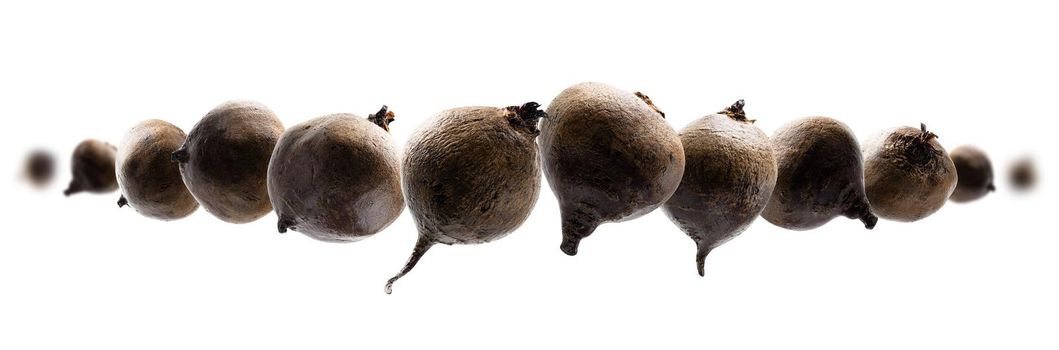 Ripe beets levitate on a white background.
