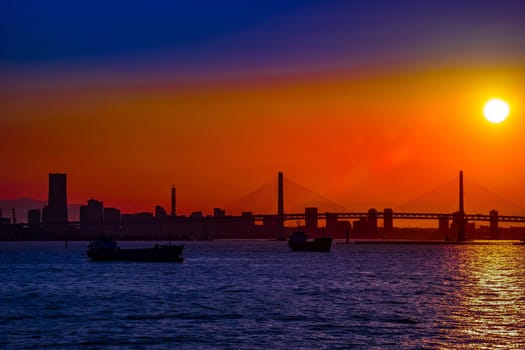 Cargo ship silhouette and evening view of Yokohama cityscape. Shooting Location: Yokohama-city kanagawa prefecture