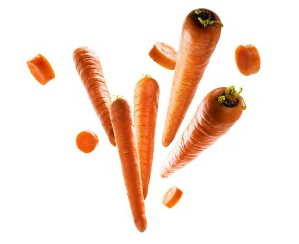 Ripe carrots whole and sliced levitate on a white background.