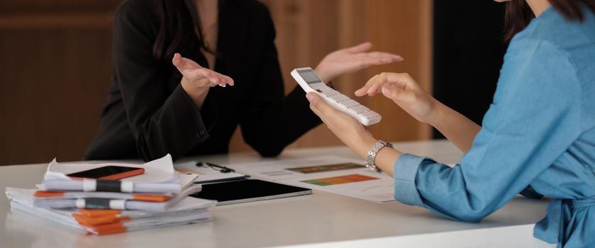 Business asian people analyzing investment graph meeting brainstorming and discussing plan in meeting room, investment number calculation concept.