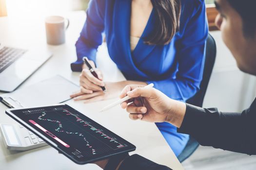 Risk Management Concept, Male stock marketer is using tablet to teach women how to invest in stocks to plan for stock market risk