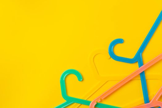 Hanger on colored paper background. Minimalistic fashion concept. Top view