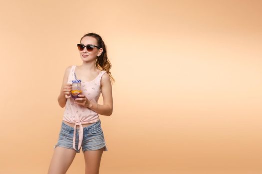 A woman in bright clothes, a T-shirt and denim shorts, sunglasses