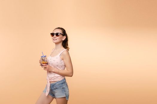 A woman in bright clothes, a T-shirt and denim shorts, sunglasses