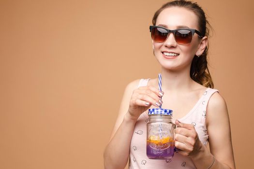 A woman in bright clothes, a T-shirt and denim shorts, sunglasses