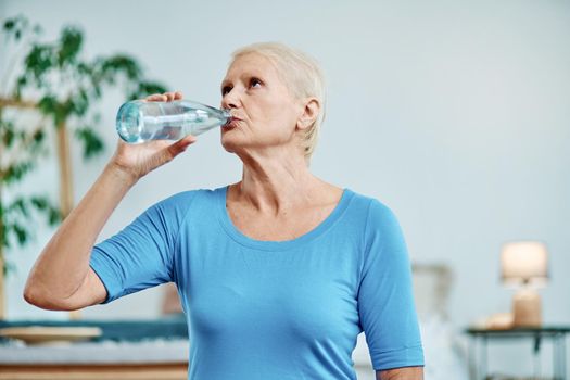 elderly woman drinks water after a morning workout. concept of a healthy lifestyle.
