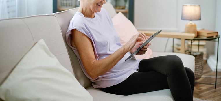 elderly woman looking at the screen of her digital tablet . close-up.